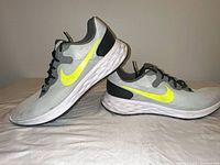 Side view showing both shoes, swoosh logos, wavy midsoles