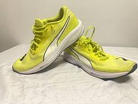 Side view of both shoes showing neon yellow uppers and Profoam Lite midsoles