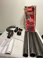 Full kit laid out: four extension tubes, elbow nozzle, flexible tube, connection collars, straps, manual, box
