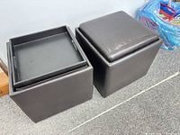Two leather cube ottomans, one with cushion side up, one with tray visible