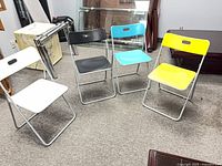 Four coloured folding chairs grouped together