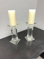 Two clear glass Bowring candle holders side by side with ivory candles for scale