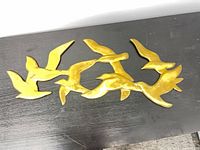 Front view of brass bird wall sculpture