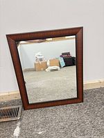 Front view of rectangular mirror with brown frame