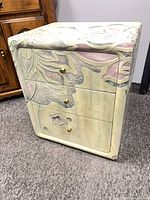 Front view of hand painted side table showing three drawers closed