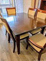 Table with six chairs around it showing wood finish and upholstery