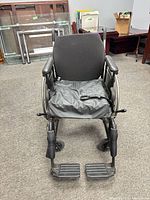 Front view of wheelchair showing seat cushion, armrests, footrests