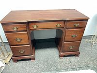 Front view of desk showing drawer arrangement and brass handles