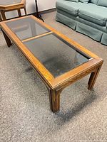 Full view of rectangular wood coffee table with smoked glass inserts