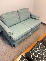 Front angled view of teal patterned loveseat