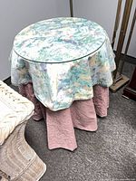 Side view of table showing glass top, fabric skirt and size
