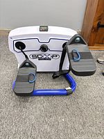 Front view of Scoop lateral trainer showing pedals, base, and branding