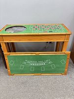 Table with roulette felt installed and separate blackjack felt board