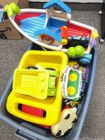 Tote showing interactive boat, dump truck bed, electronic toy, small cars