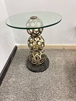 Full view of side table showing glass top and pedestal