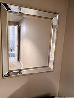 Front view of rectangular wall mirror with mirrored beveled frame