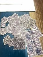 Pile of violet 3¢ Lincoln stamps spread on surface