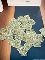 Pile of green 1¢ Franklin stamps on surface