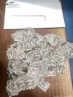 Pile of over 140 gray 15-cent Statue of Liberty stamps spread on table