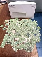 Envelope back and spread of ~200 green 1-cent Franklin stamps