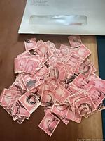 Pile of pink 20¢ Golden Gate stamps spilled from envelope