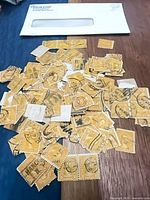 Group of orange 10¢ James Monroe stamps spread on table with envelope in background