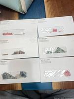Six window envelopes with assorted stamps in red, green, blue visible