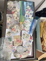 Overview of multiple bags of loose used stamps on table