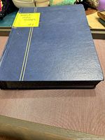 Closed blue stamp album showing cover and spine