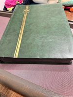 Closed green album with gold stripe