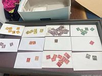 Tray with ten index cards holding assorted U.S. stamps plus storage box