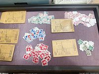 Overview of several piles of assorted used Canadian stamps on tray with three brown envelopes nearby