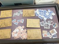 Tray with several groups of loose cancelled stamps and manila envelopes