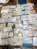 overview of numerous glassine envelopes containing assorted stamps spread on table