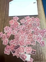 Pile of over 200 red 2¢ George Washington stamps on table