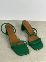 Top view of both green strappy sandals showing square toe and strap arrangement