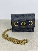 Front view showing Guess logo pattern, gold G hardware, chain strap
