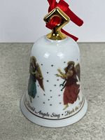 Front view of porcelain bell ornament with angels and text