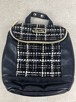 Front view showing plaid panel, logo plate, faux leather body