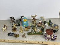 Group shot of entire assortment of small animal figurines with ruler for scale