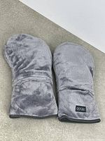 Pair of gray plush Revix therapy mittens displayed flat