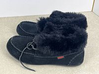 Side view of pair showing suede exterior, fur collar, moccasin stitching