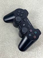 Top view of black Sony DualShock 3 controller showing buttons and sticks
