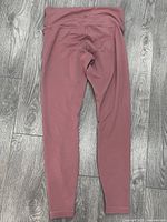Full back view of pink Lululemon leggings showing waistband logo and overall condition