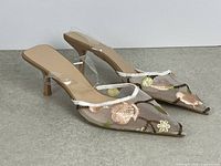 Both shoes angled to show mesh, embroidery, clear strap and heel height