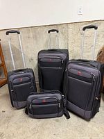 Front view showing three rolling suitcases and shoulder bag