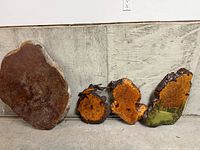 Four burl slabs leaning against wall