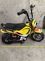 Left side view of yellow electric mini bike showing overall design and components