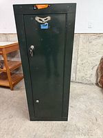 Front view of tall green metal gun safe