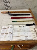 Four wind instruments laid out on table with chart, cleaning rod and swab visible